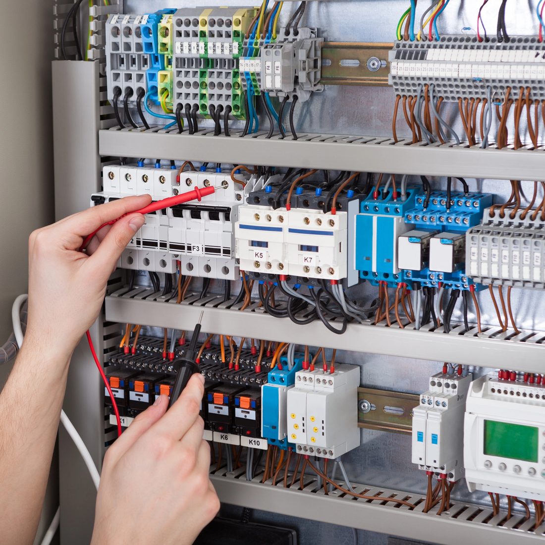 A&AT technician wiring the Taktos Edge gateway into a control panel - installed and commissioned on the line, not a license you wire up alone.